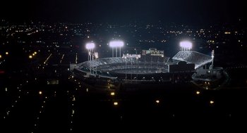Movie still from “Moneyball” (2011), directed by Bennett Miller – A stadium lit up at night with lights on; Extreme Wide shot, High angle