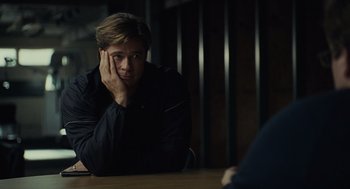 Movie still from “Moneyball” (2011), directed by Bennett Miller – A man sitting at a table with his hand on his face; Close Up shot, Over the shoulder angle