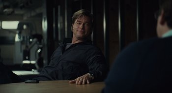 Movie still from “Moneyball” (2011), directed by Bennett Miller – A man sitting at a wooden table in a dark room; Close Up shot, Over the shoulder angle