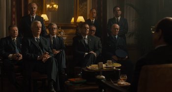 Movie still from “Operation Finale” (2018), directed by Chris Weitz – A group of men in suits sitting in front of a table; Wide shot, Low angle