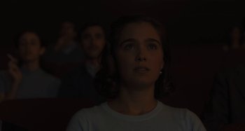 Movie still from “Operation Finale” (2018), directed by Chris Weitz – A woman in white shirt looking up in a dark room; Close Up shot, Over the shoulder angle