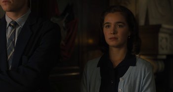 Movie still from “Operation Finale” (2018), directed by Chris Weitz – A woman in a black shirt and a white jacket; Close Up shot, Over the shoulder angle