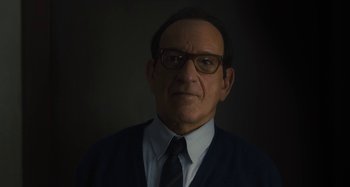 Movie still from “Operation Finale” (2018), directed by Chris Weitz – A man wearing glasses and a suit and tie; Close Up shot, Low angle