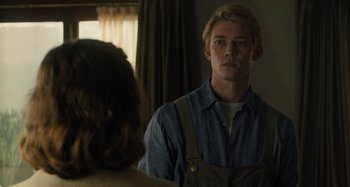 Movie still from “Operation Finale” (2018), directed by Chris Weitz – A man standing in front of a mirror looking at a woman; Medium shot, Over the shoulder angle