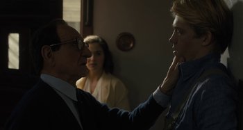 Movie still from “Operation Finale” (2018), directed by Chris Weitz – A man and a woman looking at each other in front of another man; Close Up shot, Over the shoulder angle