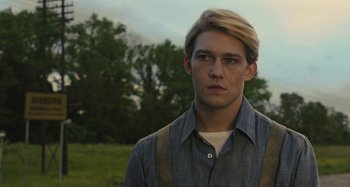 Movie still from “Operation Finale” (2018), directed by Chris Weitz – A man with blonde hair wearing a blue shirt and suspenders; Close Up shot, Low angle