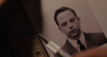 Movie still from “Operation Finale” (2018), directed by Chris Weitz – An old photo of a man; Extreme Close Up shot, High angle