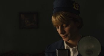 Movie still from “Operation Finale” (2018), directed by Chris Weitz – A woman wearing a hat is singing into a microphone; Close Up shot, Low angle