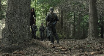 Movie still from “Operation Finale” (2018), directed by Chris Weitz – A group of men in the woods on a hike; Wide shot, Low angle