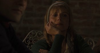 Movie still from “Operation Finale” (2018), directed by Chris Weitz – A woman sitting in front of a brick wall with her hand on her chin; Close Up shot, Over the shoulder angle