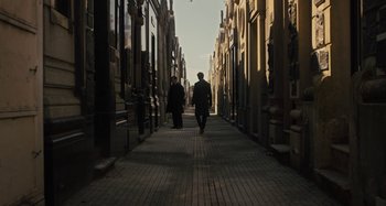 Movie still from “Operation Finale” (2018), directed by Chris Weitz – Two people are walking down a narrow alley way; Wide shot, Low angle