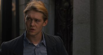 Movie still from “Operation Finale” (2018), directed by Chris Weitz – A man with blonde hair and a blue shirt; Close Up shot, Over the shoulder angle