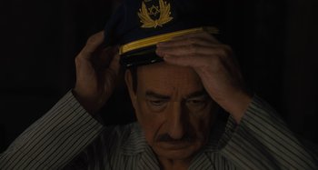 Movie still from “Operation Finale” (2018), directed by Chris Weitz – An older man wearing a hat with a star of david on it; Close Up shot, High angle