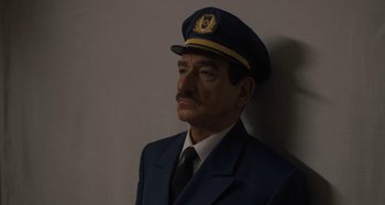 Movie still from “Operation Finale” (2018), directed by Chris Weitz – A man wearing a suit and a hat; Close Up shot, Low angle