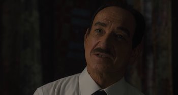 Movie still from “Operation Finale” (2018), directed by Chris Weitz – An older man wearing a white shirt and a black tie; Close Up shot, Over the shoulder angle