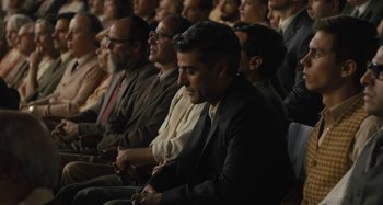 Movie still from “Operation Finale” (2018), directed by Chris Weitz – A group of men sitting in a row in a room; Medium shot, High angle
