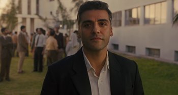 Movie still from “Operation Finale” (2018), directed by Chris Weitz – A person wearing a suit and tie; Close Up shot, Over the shoulder angle