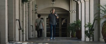 A man walking down a sidewalk next to a woman
