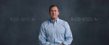 Movie still from “Operation Varsity Blues” (2021), directed by Chris Smith – A man standing in front of blackboard wearing a blue shirt; Medium shot, Over the shoulder angle
