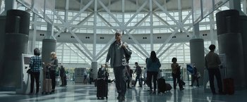 A group of people walking in an airport with luggage