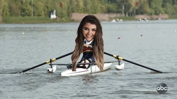 Movie still from “Operation Varsity Blues” (2021), directed by Chris Smith – A woman rowing a boat in the middle of the water; Medium shot, High angle