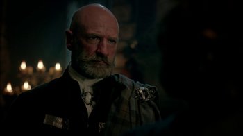 Movie still from “Outlander” (2014), created by Ronald D. Moore – A man with a bald head wearing a suit and tie; Close Up shot, Over the shoulder angle