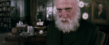 Movie still from “Moulin Rouge!” (2001), directed by Baz Luhrmann – An old man with a long white beard and mustache; Close Up shot, Low angle