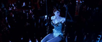 Movie still from “Moulin Rouge!” (2001), directed by Baz Luhrmann – A woman in a blue dress and a hat on a swing; Wide shot, Low angle