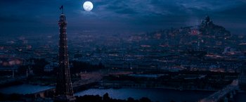 Movie still from “Moulin Rouge!” (2001), directed by Baz Luhrmann – A full moon rises over a city at night; Extreme Wide shot, High angle