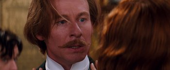 Movie still from “Moulin Rouge!” (2001), directed by Baz Luhrmann – A person wearing a suit and tie; Close Up shot, Over the shoulder angle
