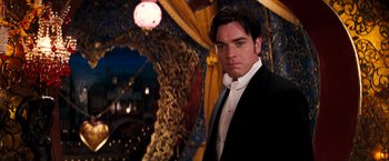 Movie still from “Moulin Rouge!” (2001), directed by Baz Luhrmann – A man in a suit standing in front of a clock; Medium shot, Low angle