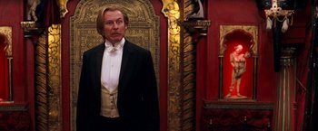 Movie still from “Moulin Rouge!” (2001), directed by Baz Luhrmann – A man in a tuxedo standing in front of an ornate wall; Medium shot, Over the shoulder angle