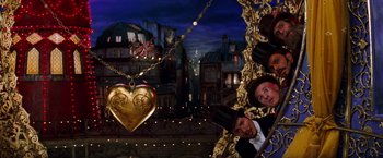 Movie still from “Moulin Rouge!” (2001), directed by Baz Luhrmann – A gold heart necklace hanging from a gold chain; Wide shot, Low angle