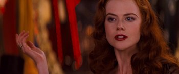 Movie still from “Moulin Rouge!” (2001), directed by Baz Luhrmann – A person with long hair and red lipstick; Close Up shot, Over the shoulder angle