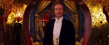 Movie still from “Moulin Rouge!” (2001), directed by Baz Luhrmann – A man in a tuxedo standing in a room; Medium shot, Low angle