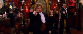 Movie still from “Moulin Rouge!” (2001), directed by Baz Luhrmann – A group of people standing in front of a painting; Medium shot, Low angle