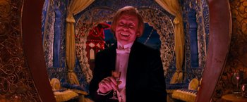 Movie still from “Moulin Rouge!” (2001), directed by Baz Luhrmann – A man in a tuxedo holding a glass of wine; Medium shot, Low angle