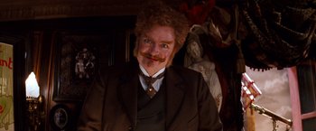 Movie still from “Moulin Rouge!” (2001), directed by Baz Luhrmann – A man in a suit and tie with a fake mustache; Close Up shot, Low angle