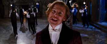 Movie still from “Moulin Rouge!” (2001), directed by Baz Luhrmann – A man in a suit and bow tie with a white bow tie; Close Up shot, Low angle