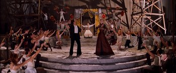 Movie still from “Moulin Rouge!” (2001), directed by Baz Luhrmann – A couple of people standing on top of a stage; Wide shot, High angle