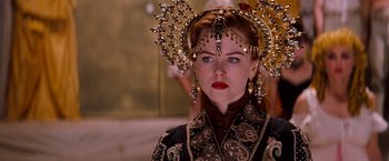 Movie still from “Moulin Rouge!” (2001), directed by Baz Luhrmann – A woman with red hair wearing a crown and earrings; Close Up shot, Over the shoulder angle