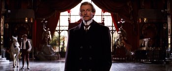 Movie still from “Moulin Rouge!” (2001), directed by Baz Luhrmann – A man in a suit and tie standing in a room; Medium shot, Low angle