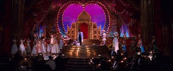 Movie still from “Moulin Rouge!” (2001), directed by Baz Luhrmann – A man standing on top of a stage in front of a crowd; Extreme Wide shot, High angle