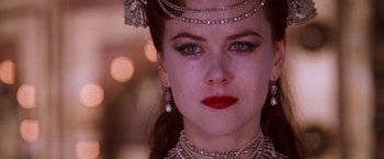Movie still from “Moulin Rouge!” (2001), directed by Baz Luhrmann – A person wearing a necklace and earrings; Close Up shot, Over the shoulder angle