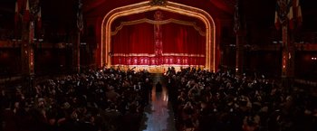 Movie still from “Moulin Rouge!” (2001), directed by Baz Luhrmann – An audience is gathered in front of a stage; Extreme Wide shot, High angle