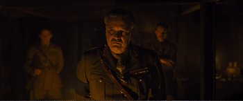 Movie still from “1917” (2019), directed by Sam Mendes – A man in a military uniform standing in a dimly - lit room; Close Up shot, Low angle