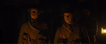 Movie still from “1917” (2019), directed by Sam Mendes – A couple of men standing next to each other in uniform; Medium shot, Low angle