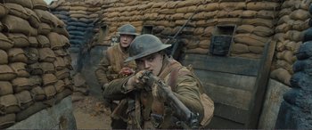 Movie still from “1917” (2019), directed by Sam Mendes – Two men dressed in world war i uniforms and helmets; Medium shot, Low angle