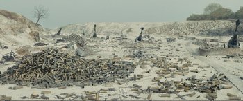 Movie still from “1917” (2019), directed by Sam Mendes – A pile of guns sitting on top of a sandy beach; Extreme Wide shot, High angle