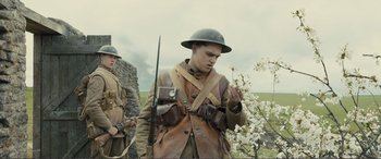 Movie still from “1917” (2019), directed by Sam Mendes – Two men in military uniforms are standing in a field; Medium shot, Low angle